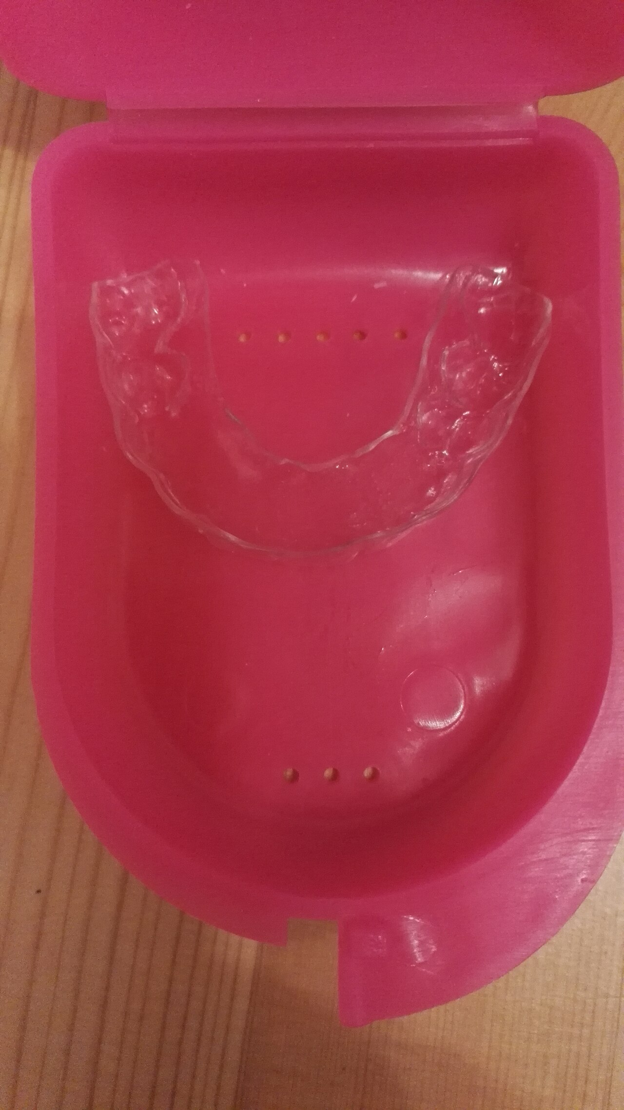 Clear dental retainer in its storage case